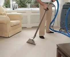 Carpet cleaning professional removing dirt and stains with a hot-water extraction tool in a home, Henderson, NV.