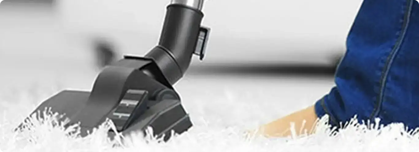 Close-up of a professional vacuuming a white carpet in Las Vegas.